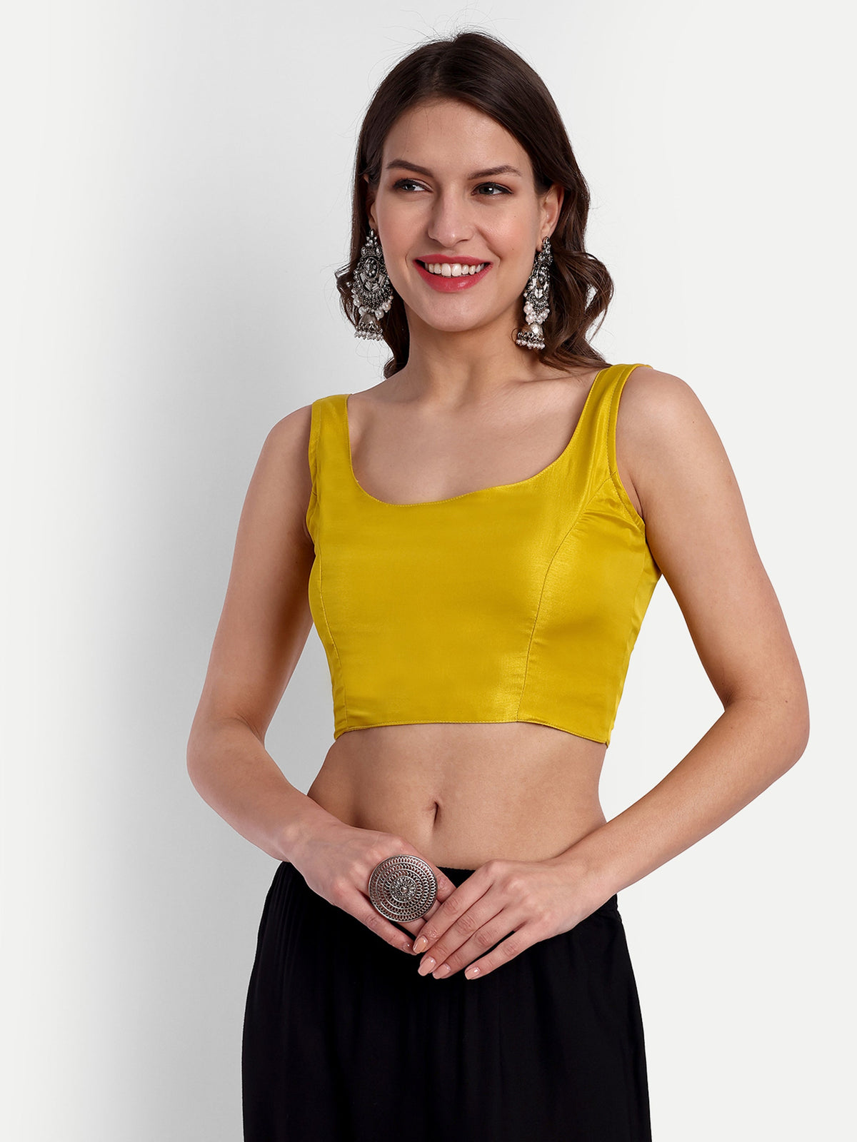 Woman wearing a mustard yellow top and black skirt on a white background