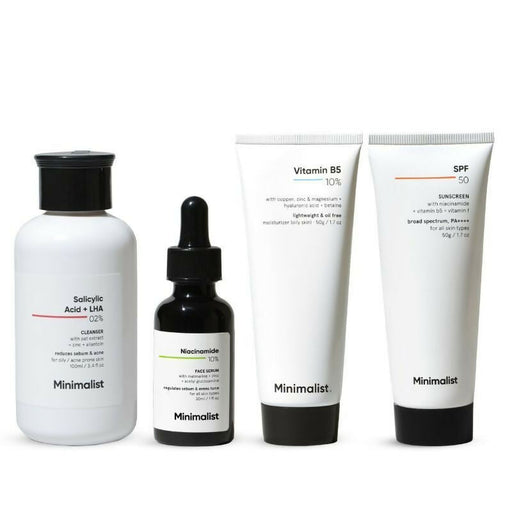 A set of four minimalist skincare products including a cleanser, serum, moisturizer, and sunscreen, each in white bottles with black text and minimalist design.