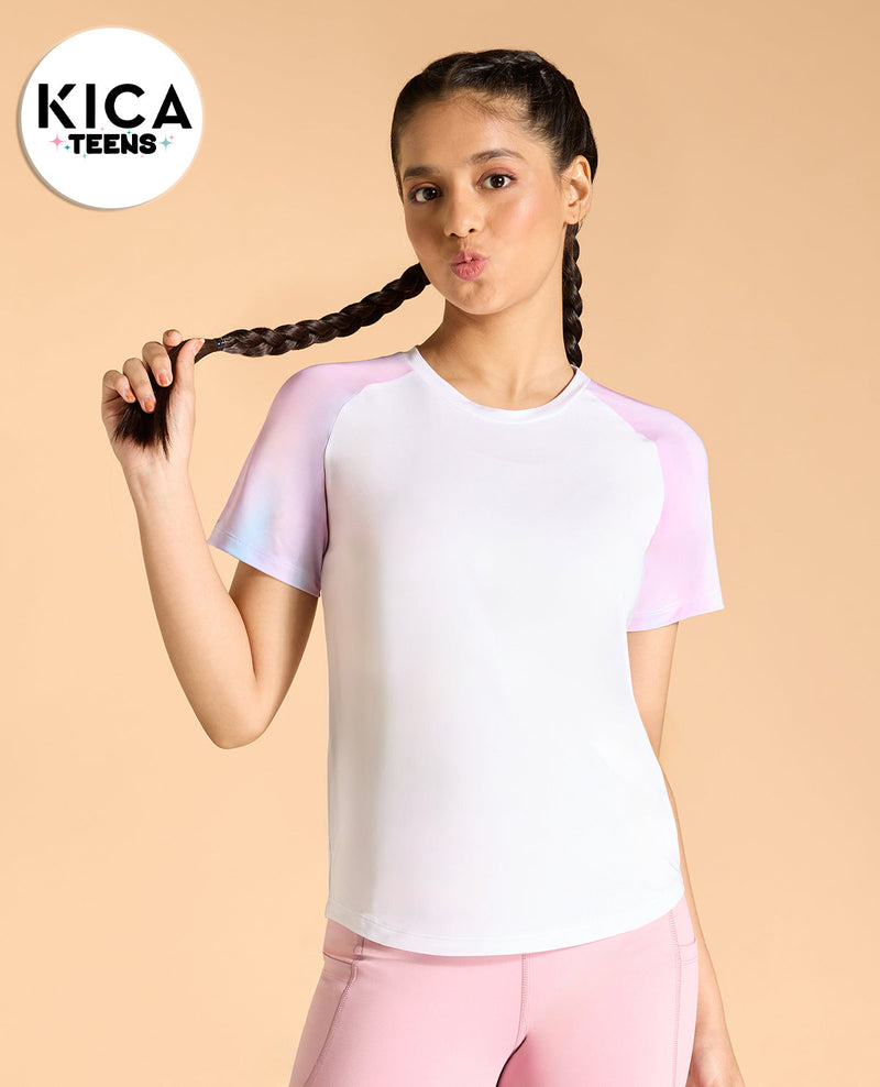 Woman wearing a white and pink outfit with 'KICA TEENS' branding on a beige background